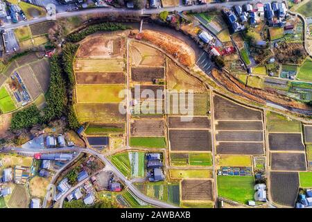 Rice field terraces along small mountain river in Ohara village near Kyoto city, Japan. Aerial top down view. Stock Photo