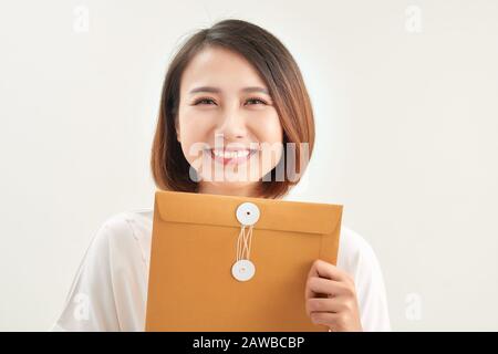 A woman is holding and giving a big brown envelope with blank space on it Stock Photo