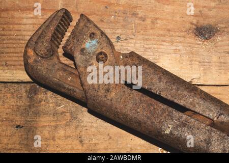 Pipe wrench on wood background. adjustable gas wrench. instrument for repair. working tool Stock Photo