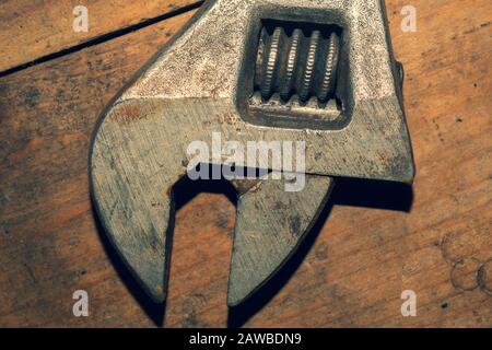 Old adjustable wrench on wood background. working tool. plumbing repairing instrument Stock Photo