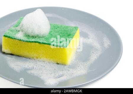 Foam sponge for washing dishes, dirty gray plate on a white background with foam Stock Photo