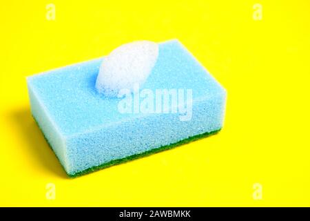 Blue sponge for washing dishes on a yellow background. Stock Photo