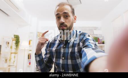 Pov young influencer talking with the audience from his vlogs. Creative and cheerful man. Stock Photo