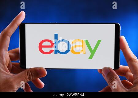 POZNAN, POL - JUL 10, 2019: Hands holding smartphone displaying logo of Groupon is an American worldwide e-commerce marketplace connecting subscribers Stock Photo