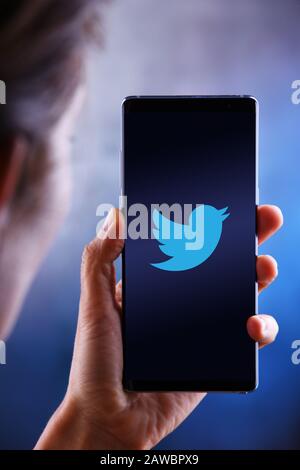 POZNAN, POL - JUL 10, 2019: Woman holding smartphone displaying logo of Twitter, an American online microblogging and social networking service Stock Photo