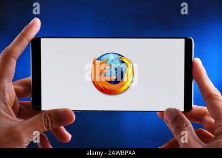 POZNAN, POL - JUL 10, 2019: Hands holding smartphone displaying logo of Firefox, a free and open-source web browser. Stock Photo