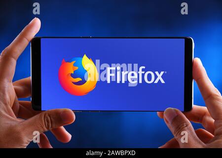 POZNAN, POL - JUL 10, 2019: Hands holding smartphone displaying logo of Firefox, a free and open-source web browser. Stock Photo