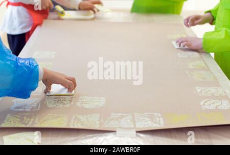 Close-up of a children in art therapy class drawing, painting and practicing engraving art. Child education in primary school at art class in Spain. Stock Photo