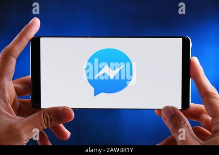 POZNAN, POL - JUL 10, 2019: Hands holding smartphone displaying logo of Facebook Messenger, a messaging app and platform Stock Photo