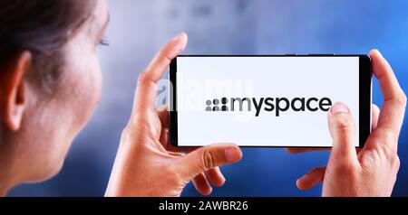 POZNAN, POL - JUL 10, 2019: Woman holding smartphone displaying logo of Myspace, a social networking website. Stock Photo