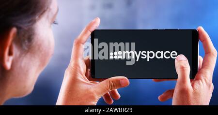 POZNAN, POL - JUL 10, 2019: Woman holding smartphone displaying logo of Myspace, a social networking website. Stock Photo