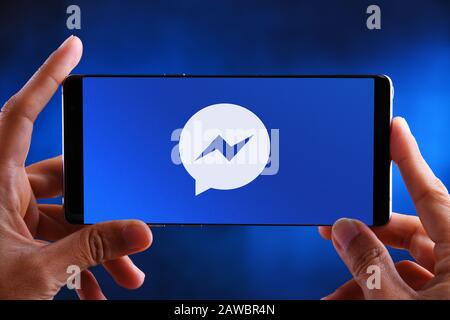 POZNAN, POL - JUL 10, 2019: Hands holding smartphone displaying logo of Facebook Messenger, a messaging app and platform Stock Photo