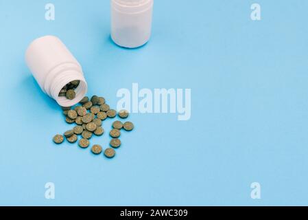 Painkillers. Plastic jars with green pills on a blue background. Top view, copy space Stock Photo