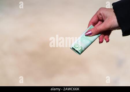 Woman hand holding and giving money. World money concept, close up of 100 EURO banknote, photo of EUR currency isolated. Hand holding money, EURO curr Stock Photo