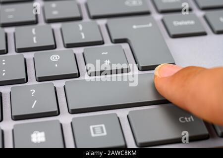 Finger pressing the shift key on keyboard Stock Photo