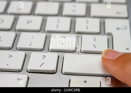 Finger pressing the shift key on keyboard Stock Photo
