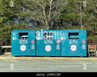 WOODBRIDGE, NEW JERSEY / UNITED STATES - January 9, 2020: Three clothing and shoes donation bins located in a local shopping mall parking lot. These b Stock Photo