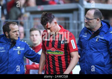 Freiburg, Germany. 08th Feb, 2020. Football: Bundesliga, SC Freiburg - 1899 Hoffenheim, 21st matchday in the Black Forest Stadium. Robin Koch of Freiburg leaves the field bleeding with a head wound. Physiotherapist Uwe Vetter is running on the left and team doctor Jochen Gruber on the right. Photo: Patrick Seeger/dpa - IMPORTANT NOTE: In accordance with the regulations of the DFL Deutsche Fußball Liga and the DFB Deutscher Fußball-Bund, it is prohibited to exploit or have exploited in the stadium and/or from the game taken photographs in the form of sequence images and/or video-li Stock Photo