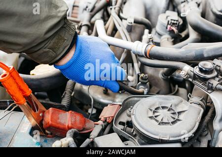 Car mechanic engineer checking, fixing the car, making maintenance comprehensive auto check. Auto mechanic in blue gloves detected breakdown and Stock Photo