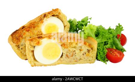 Scotch egg quiche with shortcrust pastry and whole egg encased in pork sausage meat with fresh salad isolated on a white background Stock Photo