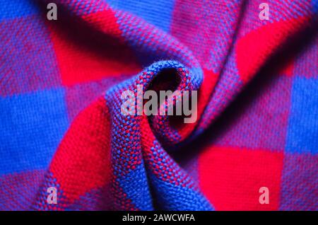 Plaid material. Red and blue cage clothes. Crumpled twisted fabric background Stock Photo