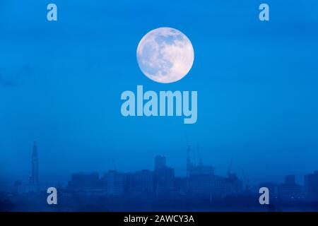 Birmingham, UK. 8th Feb, 2020. A rising full moon appears over Birmingham city centre, UK. The full moon in February is sometimes referred to as a snow moon. Opinions vary amongst lunar experts as to whether this particular appearance is a 'supermoon' even though it is larger than normal. Credit: Peter Lopeman/Alamy Live News
