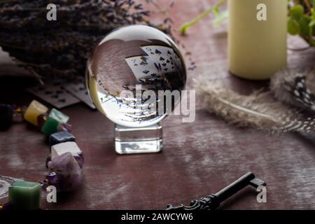 Divination with white candles, lavender, fortune-telling ball, stones, cards and key. occult and esoteric objects witch wooden table Stock Photo
