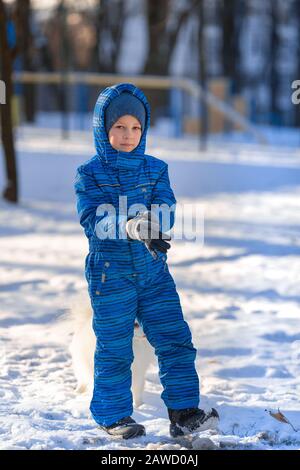 Small boy training a spitz dog in the park in winter Stock Photo