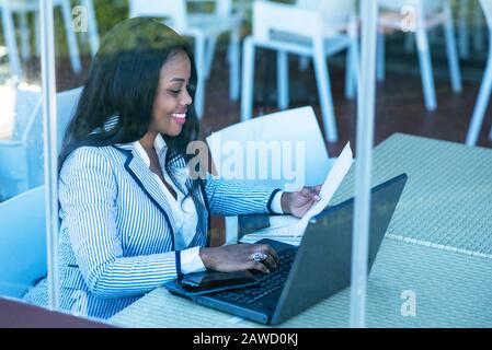 beautiful african american woman using tablet computer from home while ...