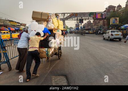 Men pushing loaded cart on road in Kolkata. India Stock Photo