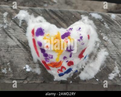 Top view  of colored snow heart on the wood made by child. Backdrop for Valentines day card. Background for hand made art shop Stock Photo