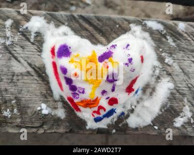 Top view  of colored snow heart on the wood made by child. Backdrop for Valentines day card. Background for hand made art shop Stock Photo