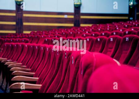 Red colored chairs at empty movie theater Stock Photo - Alamy