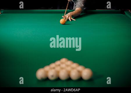 Man is player preparing and aiming to smash white balls in Russian billiards on green table. Stock Photo