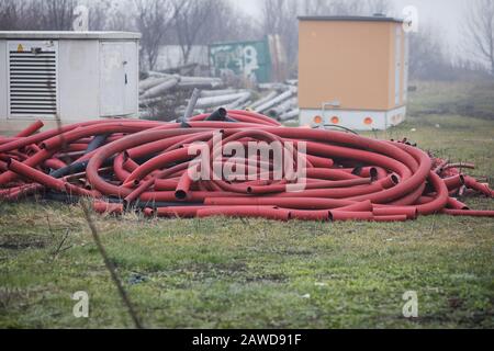 Remains of big exterior plastic protections for buried electricity cables outdoors on a rainy cold day. Stock Photo