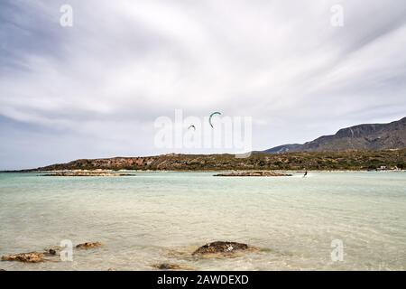 tourists enjoy amazing Elafonissi Beach in Crete island, Greece. Scenic Spot is known for its pink sand beaches. Beautiful landscape. Stock Photo