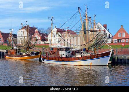 Crab cutter in the harbour in front of historical buildings, Greetsiel, Lower Saxony, Germany Stock Photo