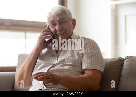 Happy elderly man talk using modern smartphone gadget Stock Photo