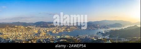 Nagasaki cityscape panorama view from Mt Inasa observation platform deck in sunny day sunset time with blue sky background, famous beauty scenic spot Stock Photo