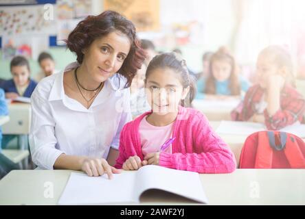 teacher and student looking at camera in the classroom and smiling Stock Photo