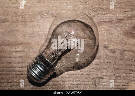 Light bulb on a wooden background. old lamp lies on the table. Stock Photo
