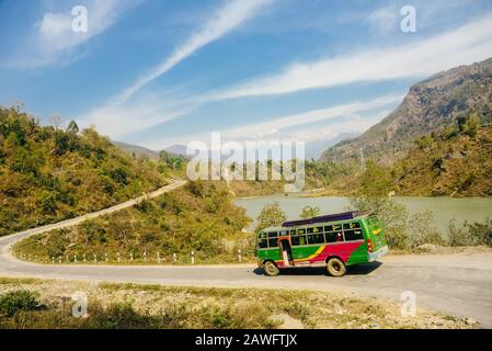 bus on the route to Annapurna base camp with background of the mountain forest and Nepali local tribe village Stock Photo