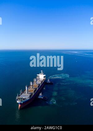 Bulk Carrier Ship berthing with tug assistance at Port Thevenard South Australia to load wheat for export Stock Photo