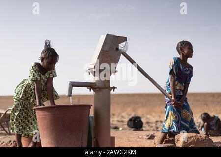 Cute African Ethnicity Infant Gathering healthful Water in a rural village Stock Photo