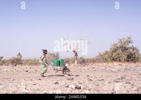 Cheerful Native African Infant Working with Clean Water in Bamako Stock Photo