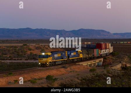 Container freight train leaving Port Augusta South Australia for the trip north to Darwin Stock Photo