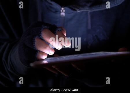 hacker hand typing on digital tablet, close up Stock Photo