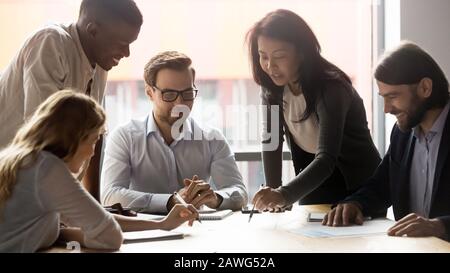 Employees with team leader working on new project at meeting Stock Photo