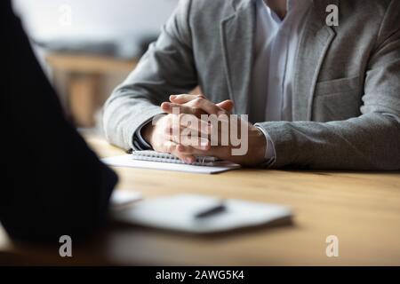 Two businessmen with clasped hands sitting opposite close up Stock Photo