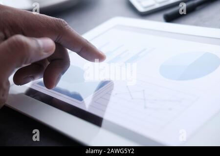 Businessman hand analyzing chart on digital tablet, closeup  Stock Photo